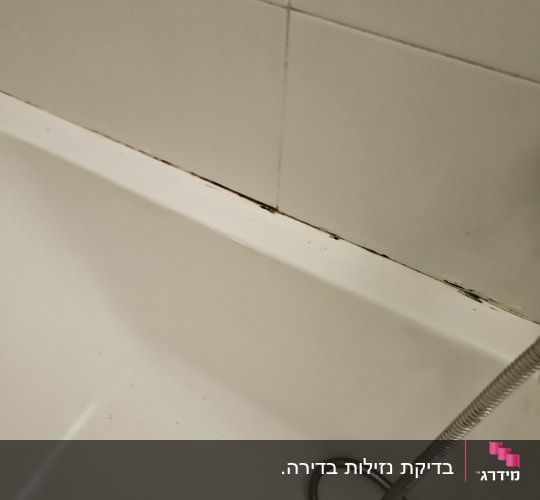 אמבטיה עם סימני עובש בקו החיבור לקיר